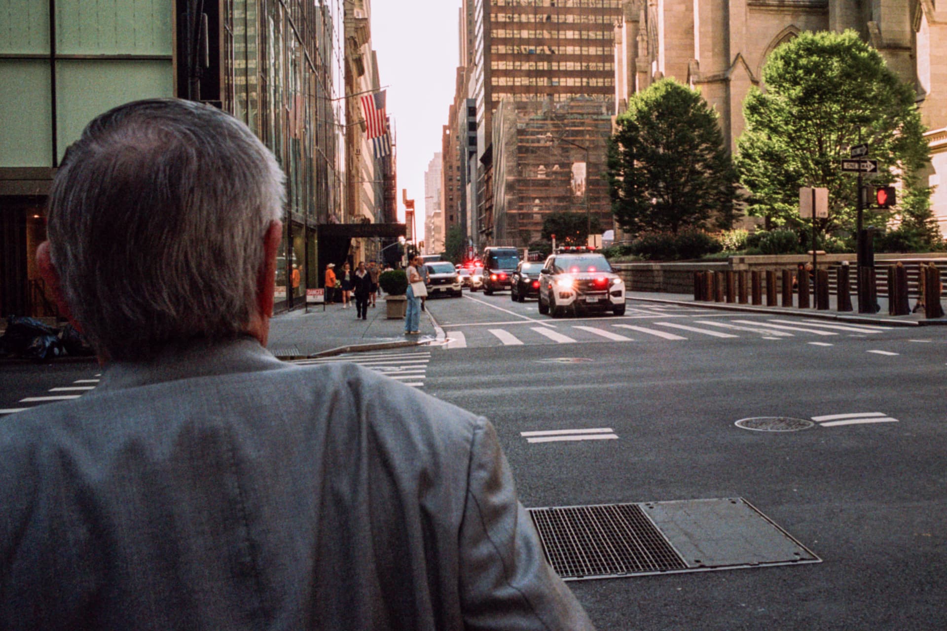 Older man watching a city street from the sidewalk